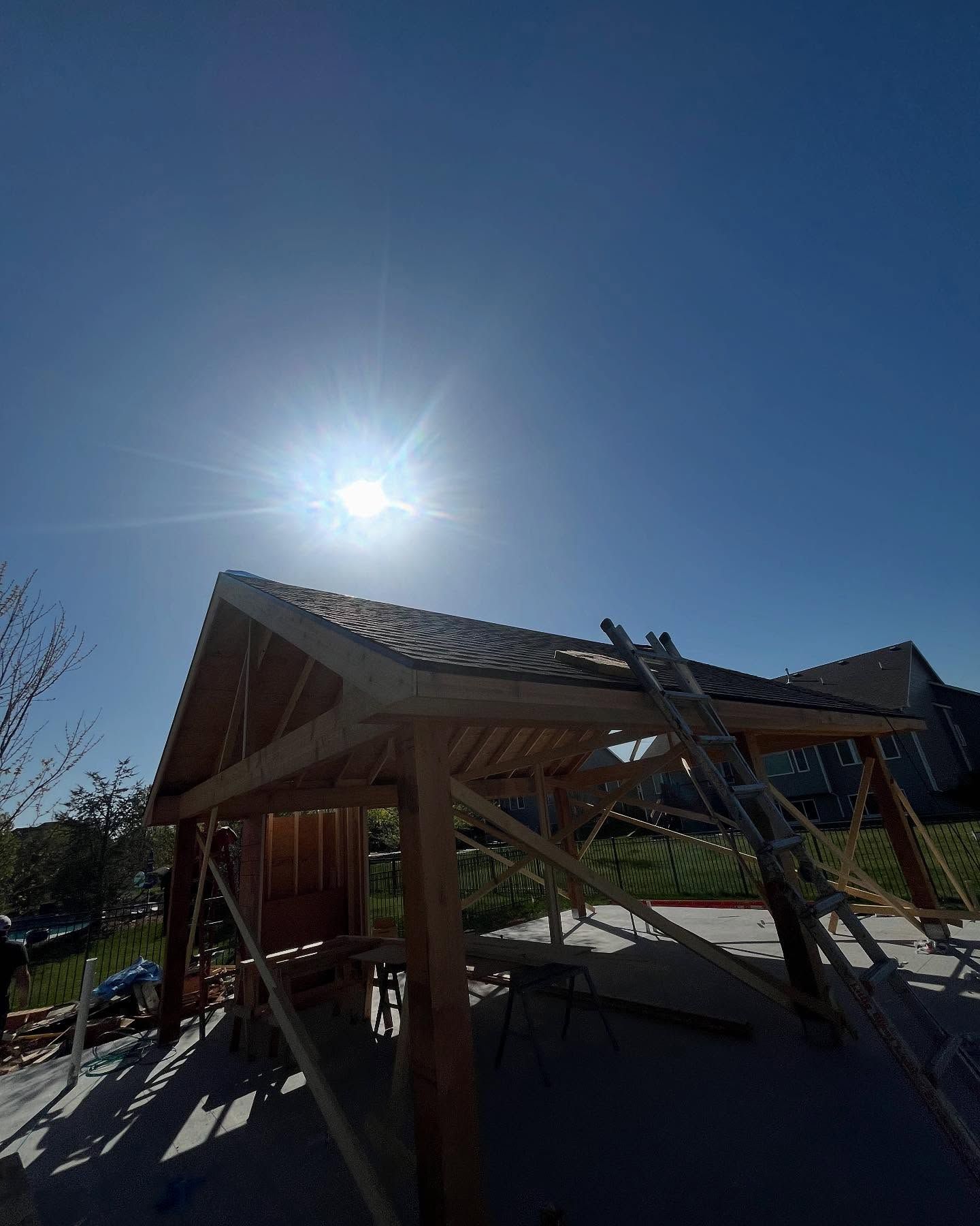 The sun is shining brightly on a wooden structure under construction