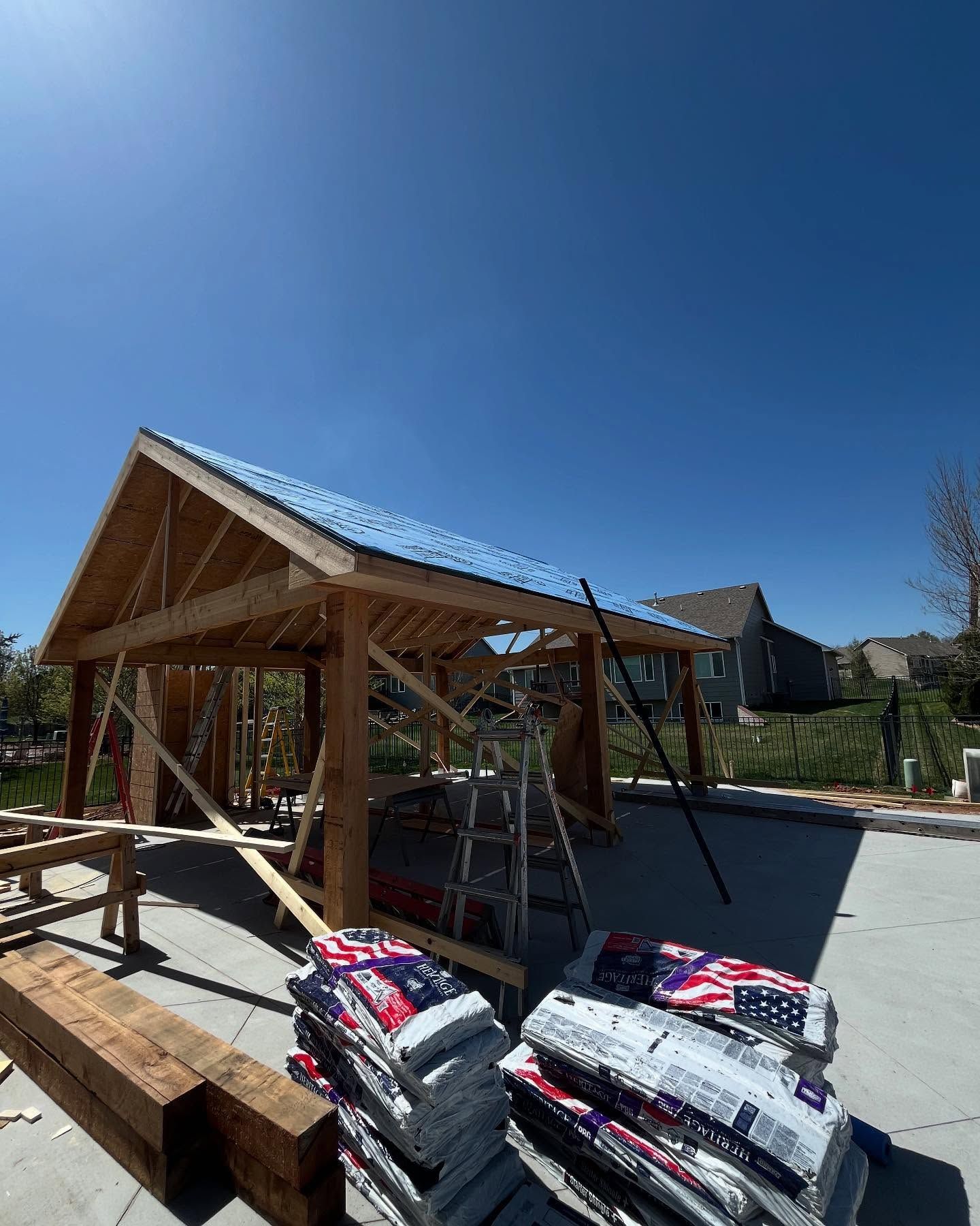 A wooden structure is being built with bags of concrete in front of it.