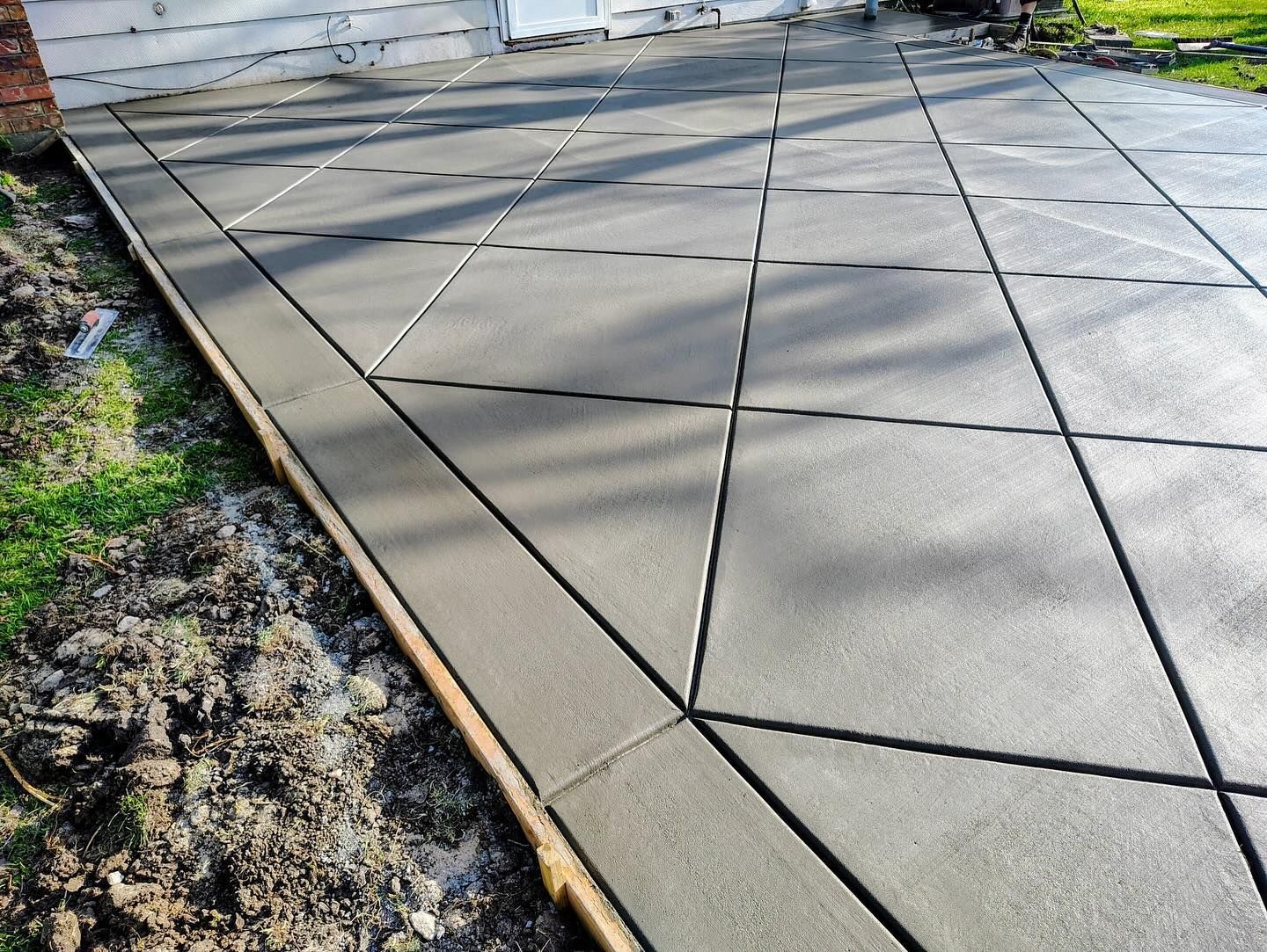 A concrete driveway is being built in front of a house.