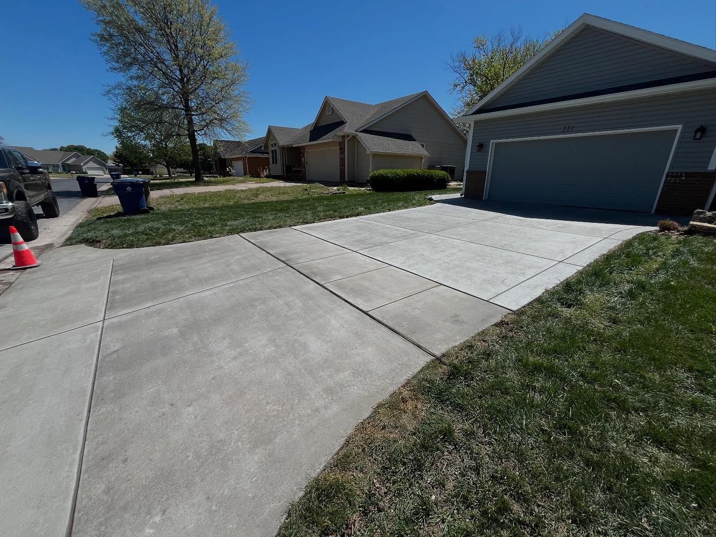 A concrete driveway in front of a house with a garage.