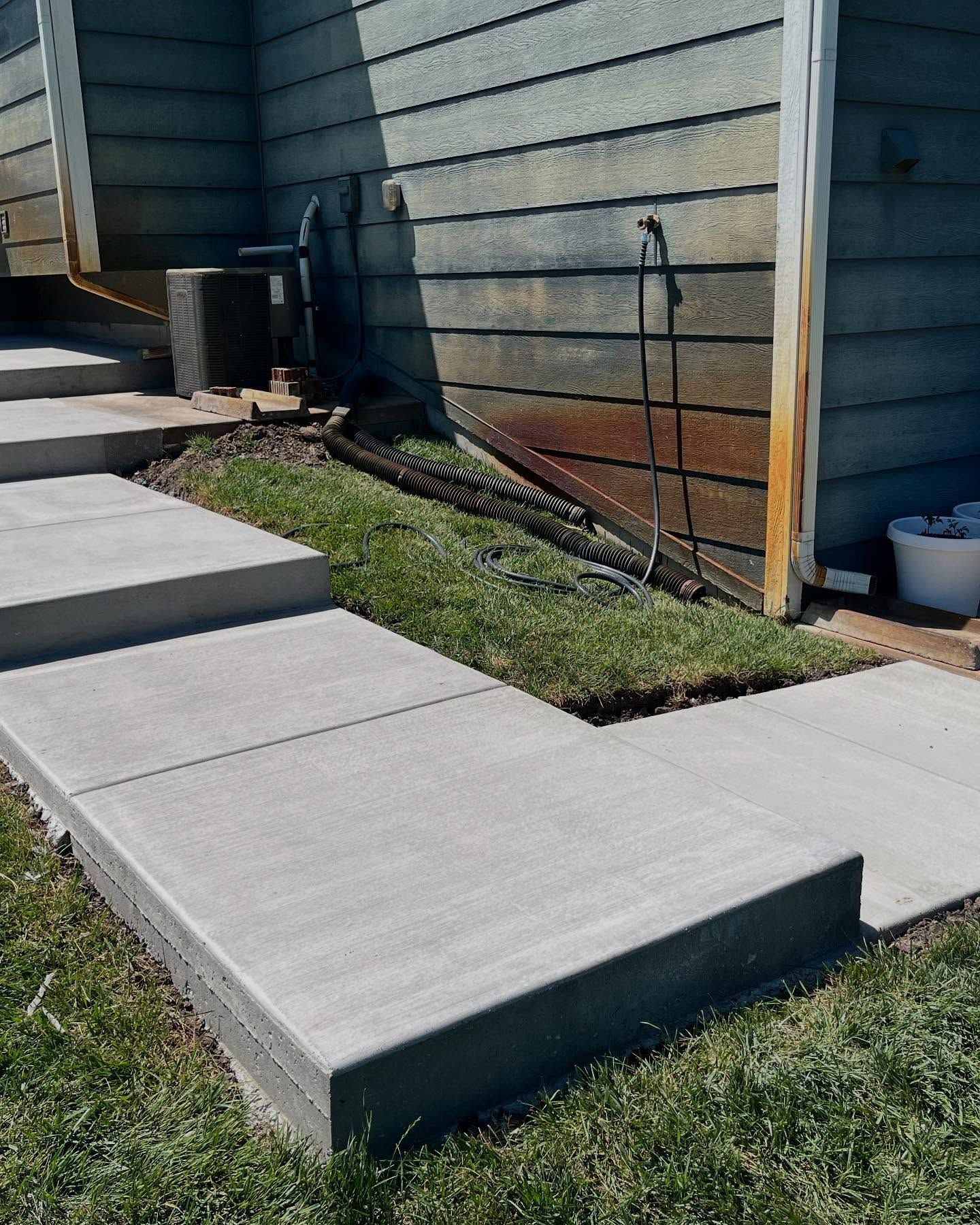 A concrete walkway next to a wooden building