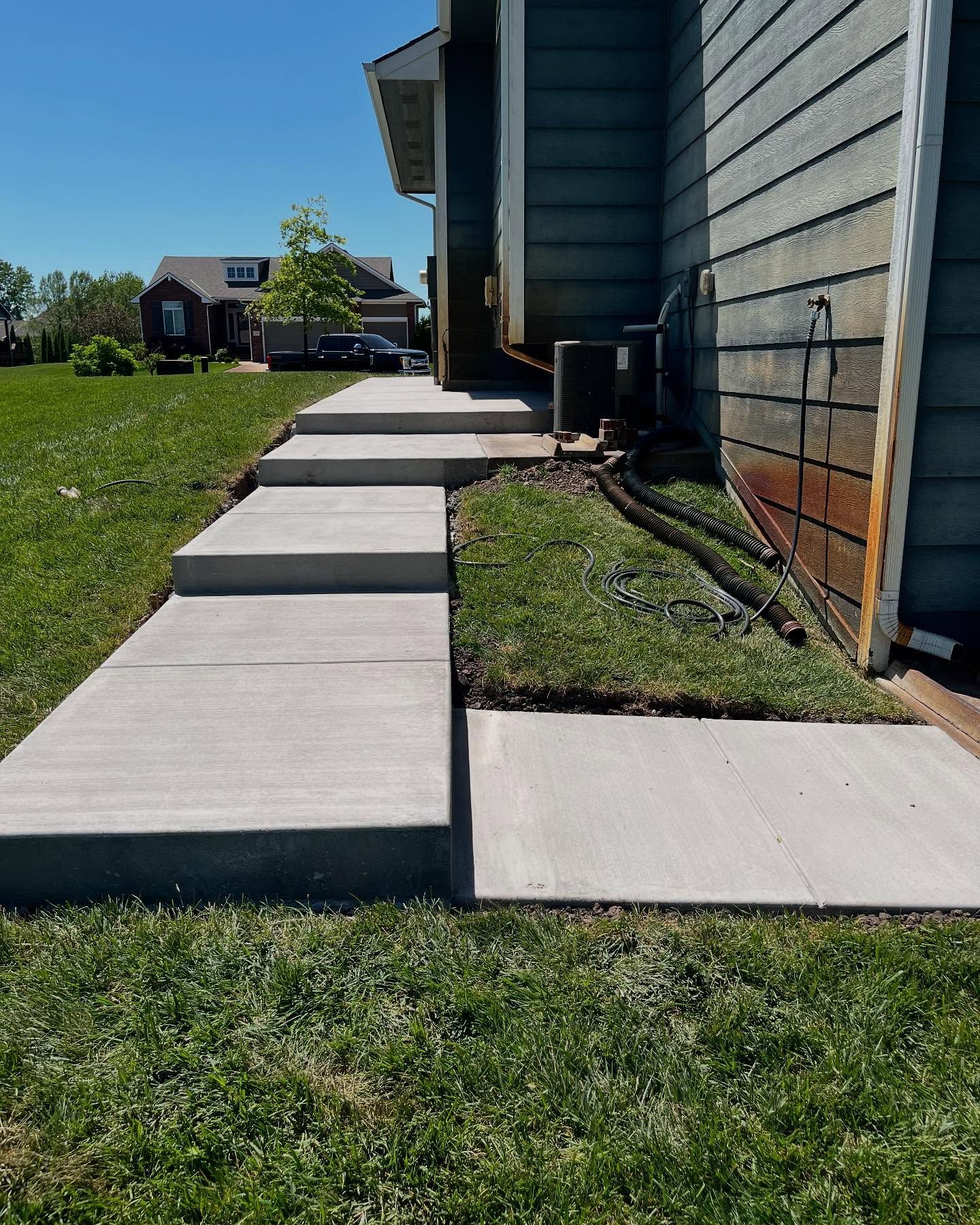 A concrete walkway leading to the side of a house.