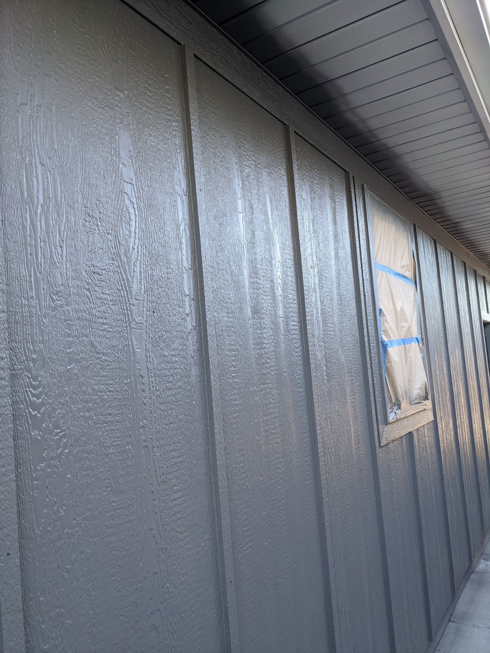 A gray wall with a window on the side of it.