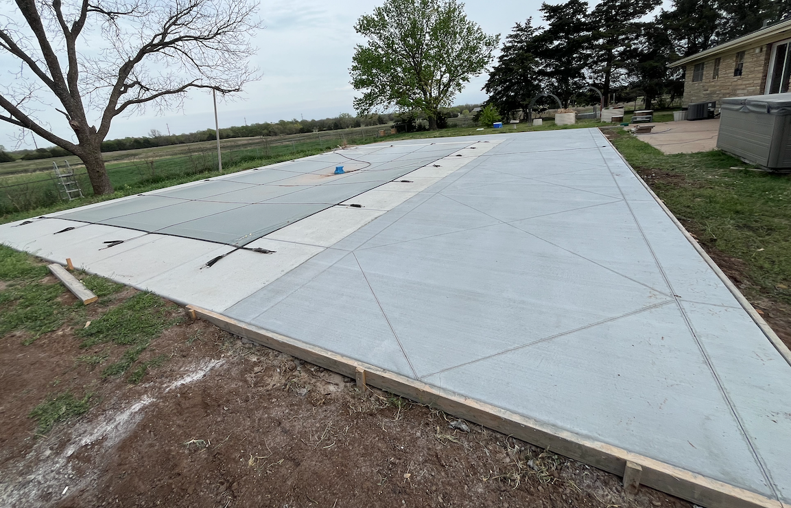 A concrete driveway is being built in front of a house.