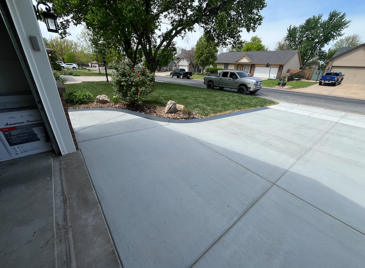 A truck is parked in a driveway next to a house