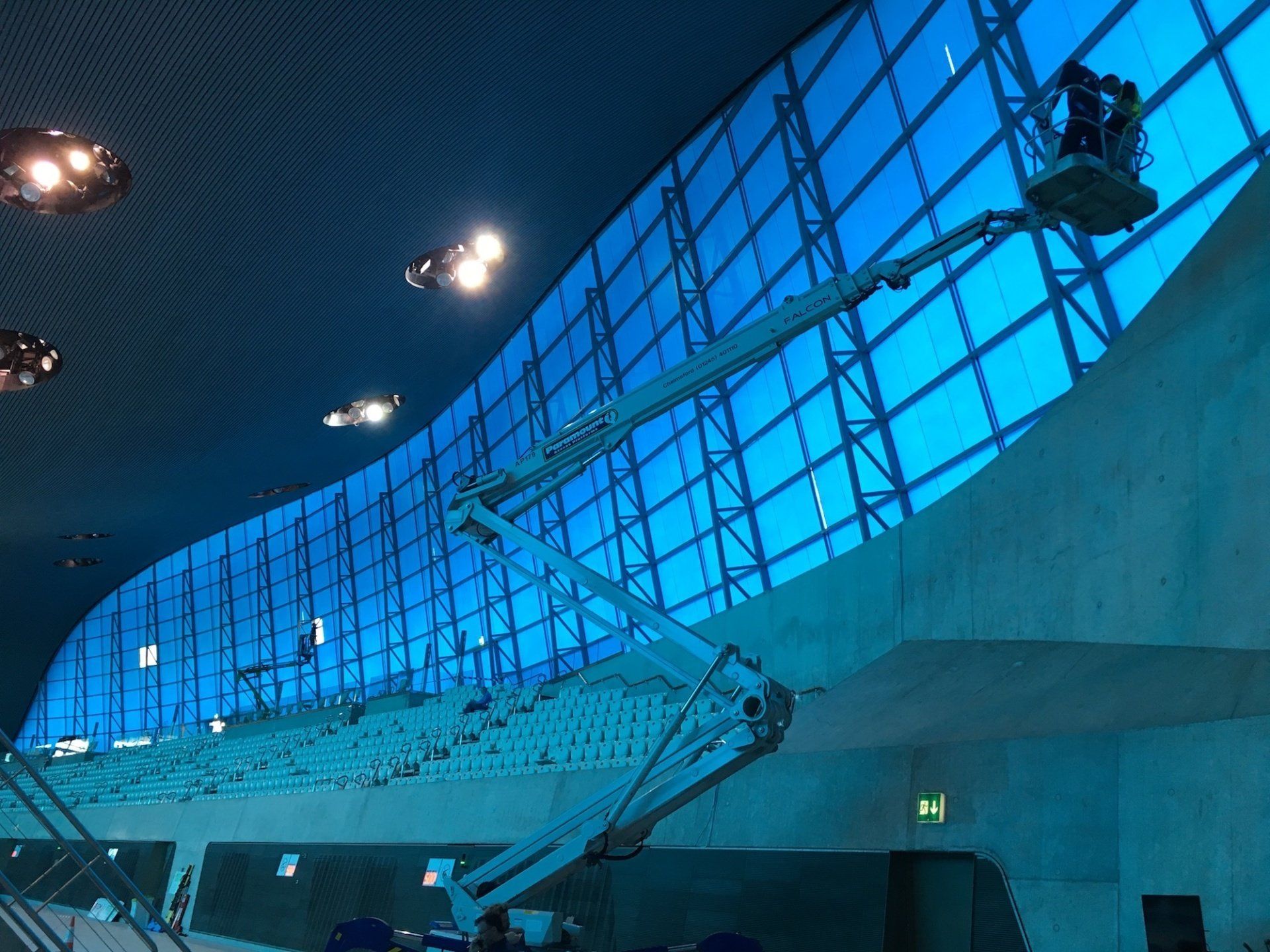 A crane is being used to clean a large window in a building.