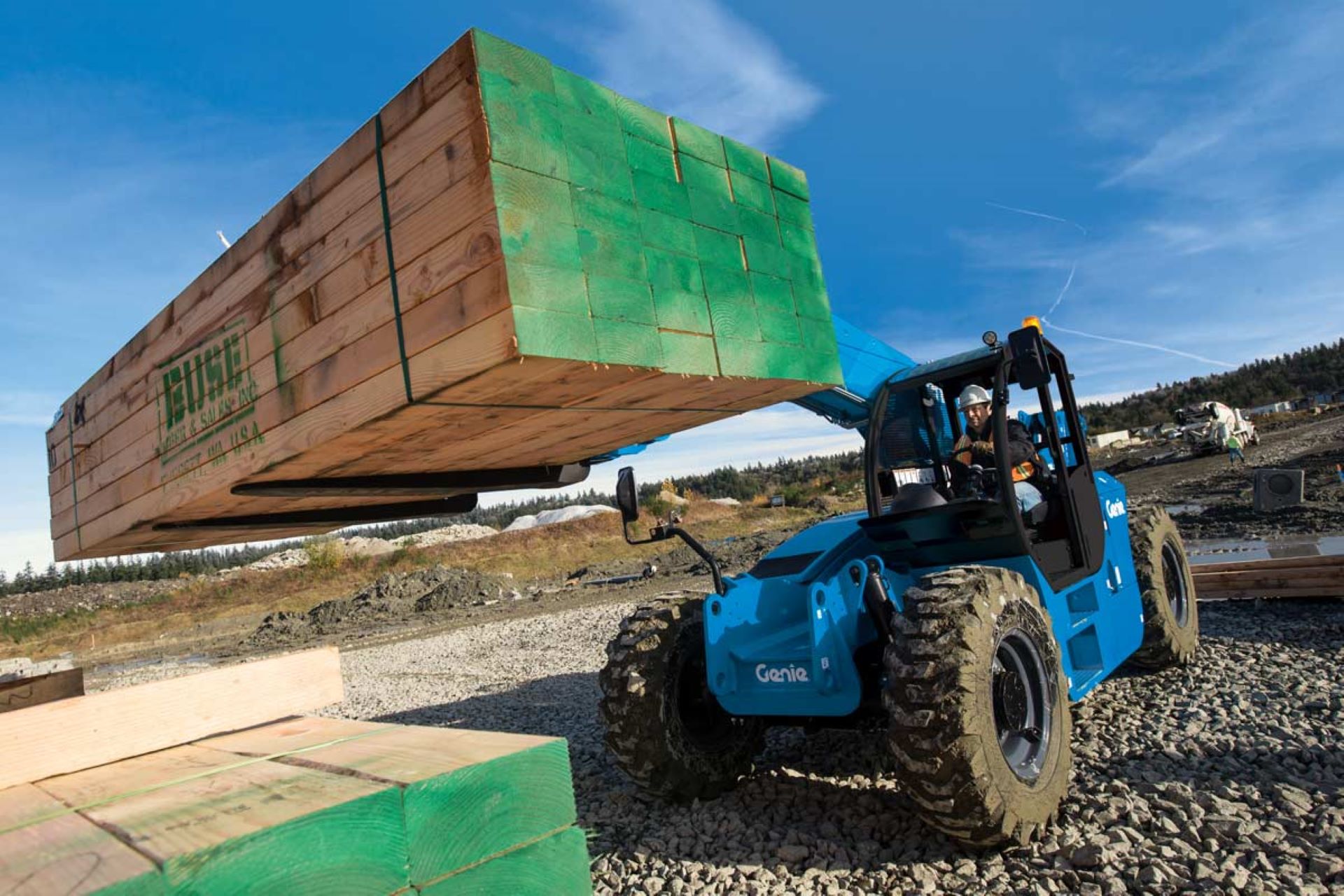 A genie forklift is carrying a large wooden box