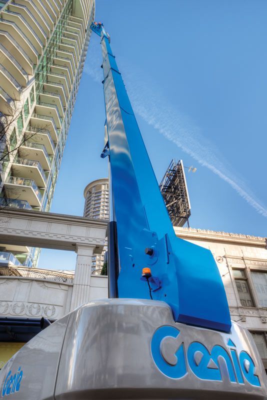 A genie crane is sitting on top of a building