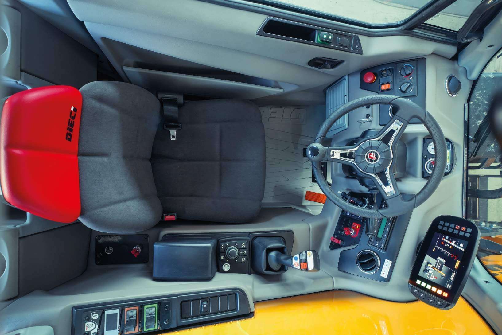 The inside of a tractor with a red seat and steering wheel