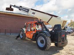 A telescopic handler is parked in front of a brick building.