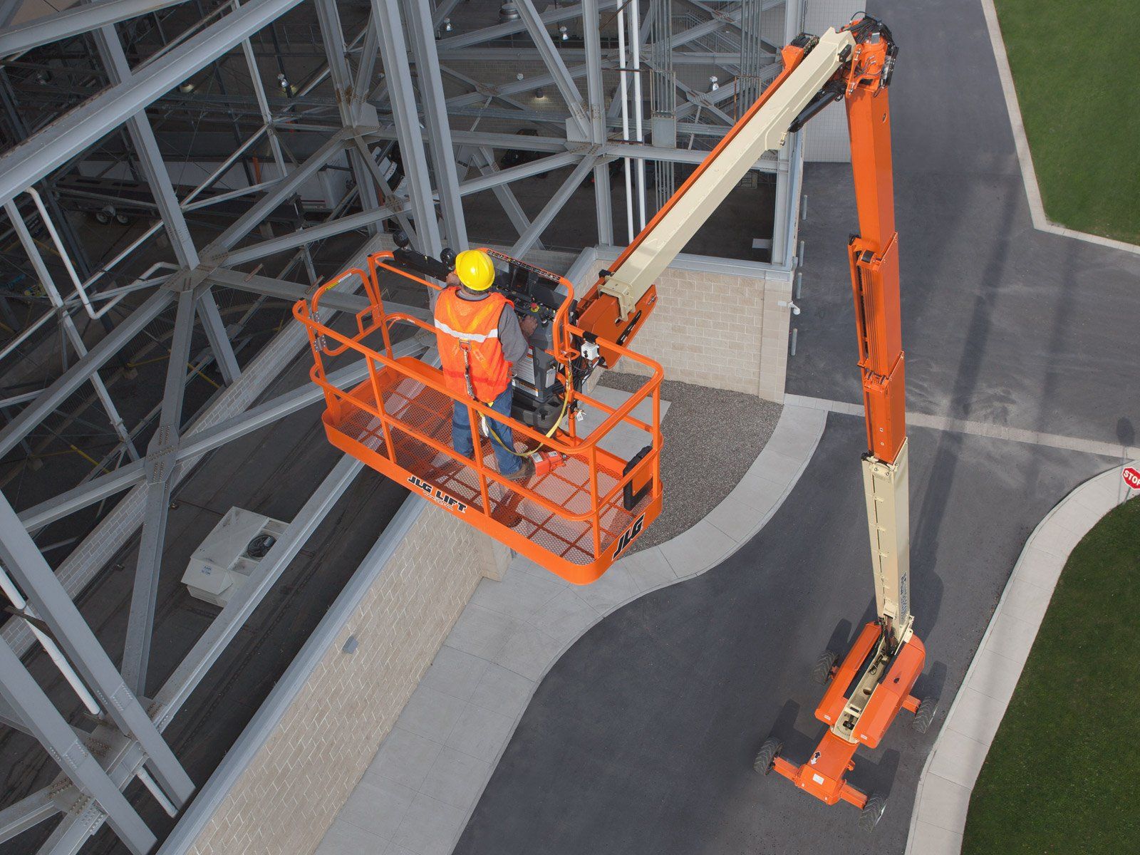An aerial view of a man in a lift working on a building