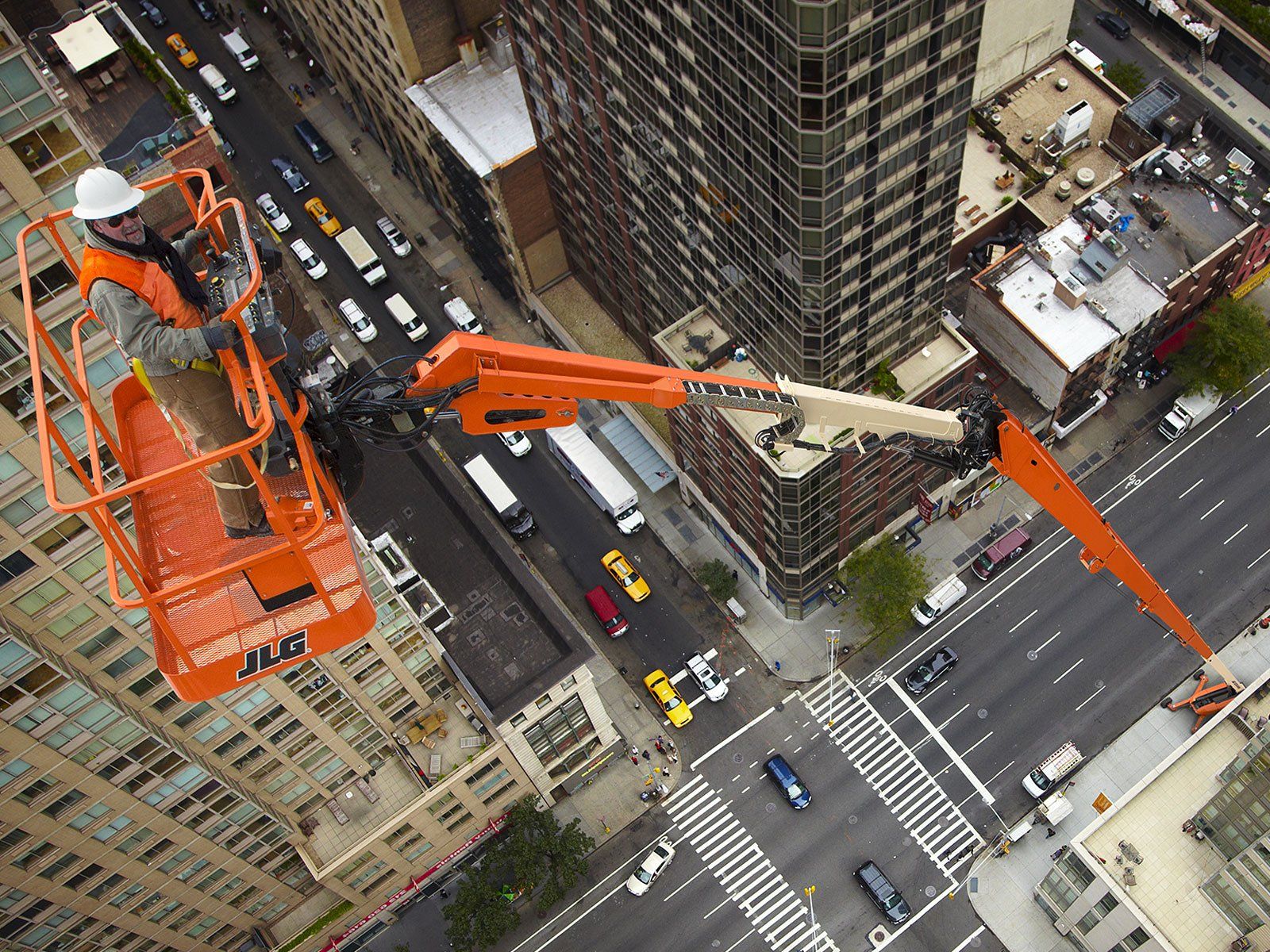 An aerial view of a man on a lift in a city