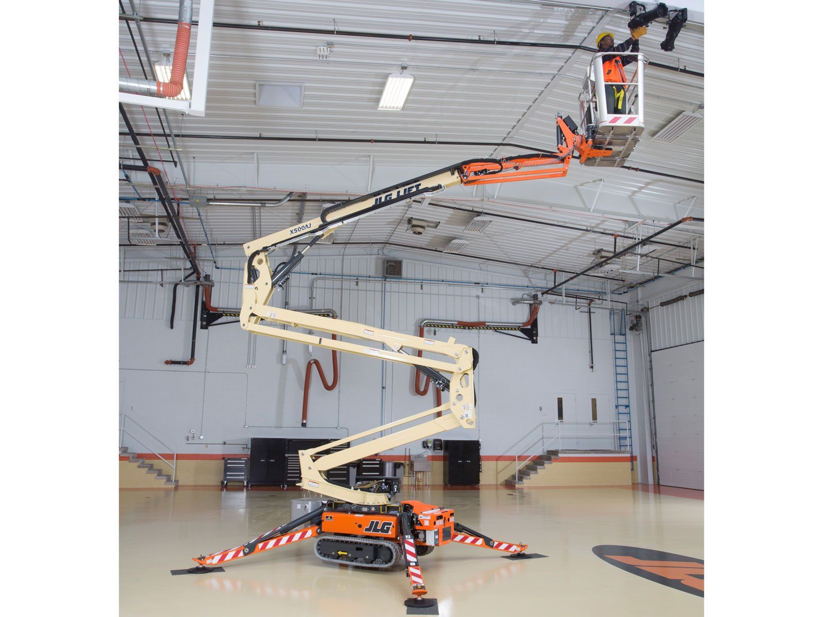 A man is working on the ceiling of a basketball court.