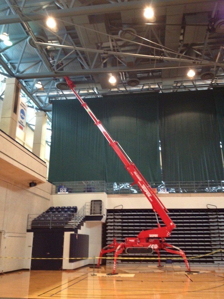 A large red crane is sitting in a gym