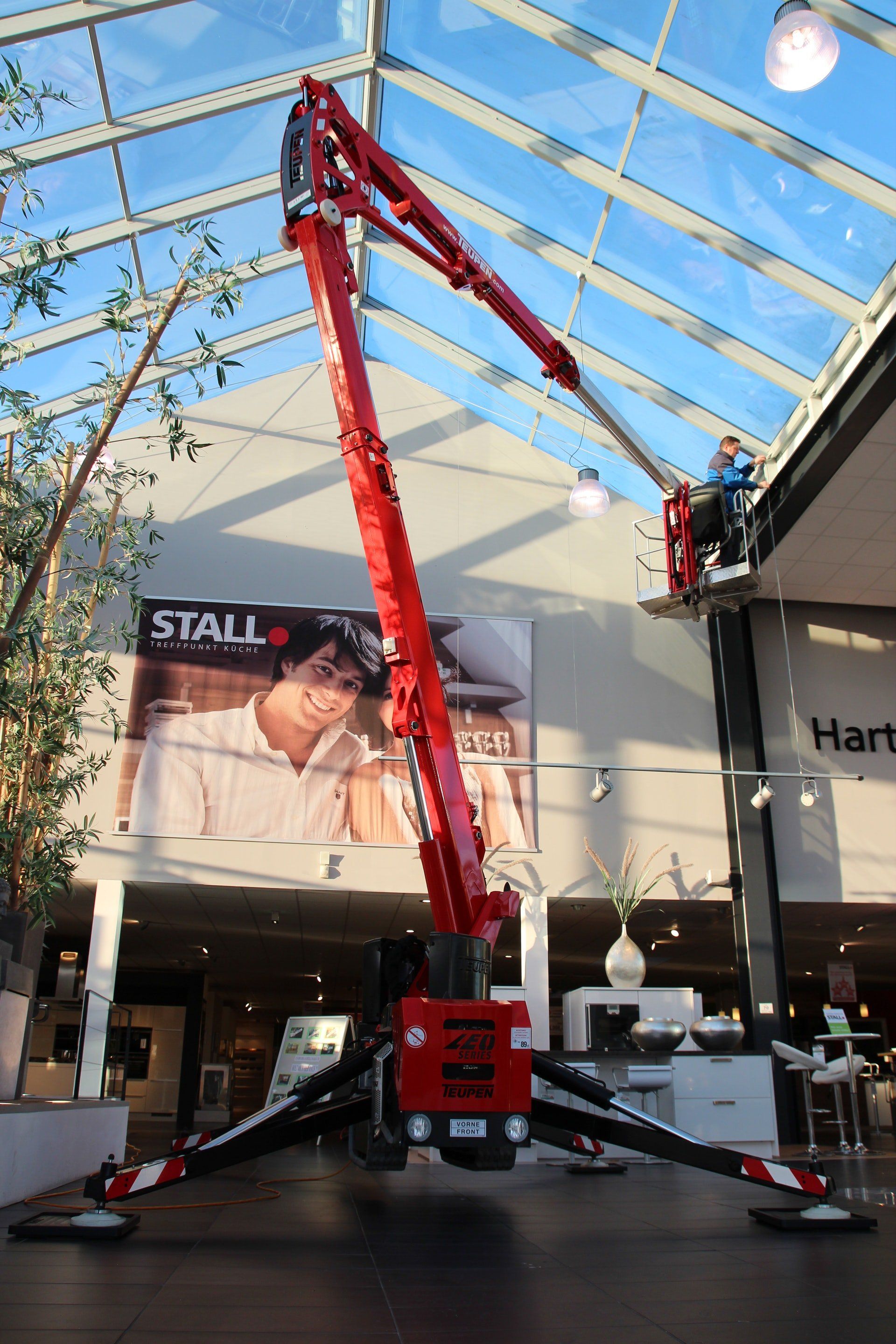 A red crane is sitting in front of a sign that says stall