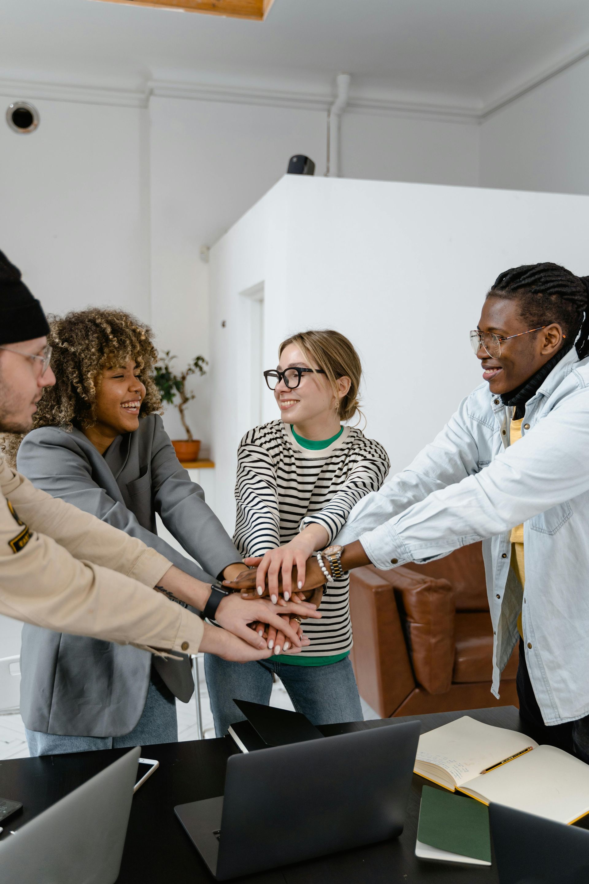Happy team putting hands together, symbolizing teamwork, collaboration, and work-life balance