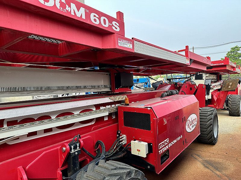 A red specialty aerial lift is parked in front of a building.
