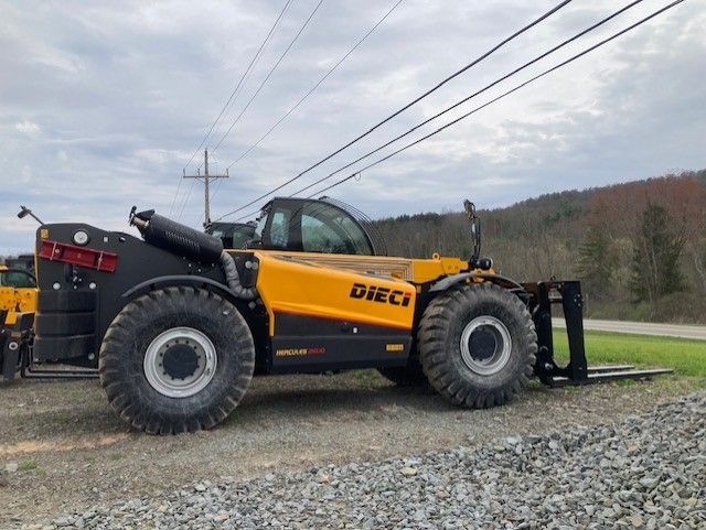 A yellow and black forklift is parked on a gravel road.