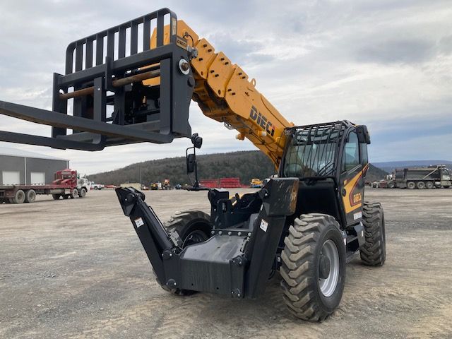 A yellow and black forklift is parked in a dirt lot.