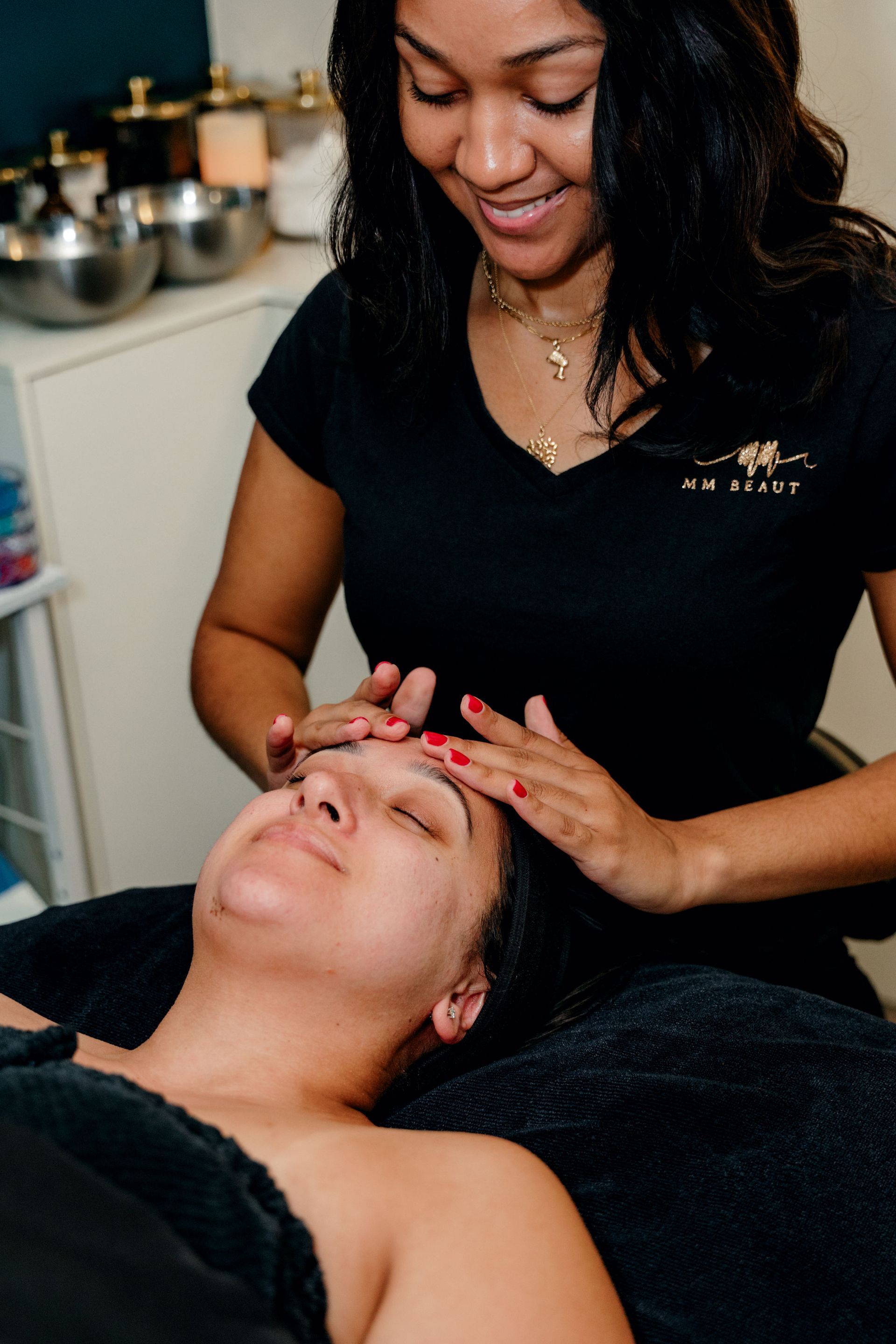 A woman is giving a woman a massage on her face.