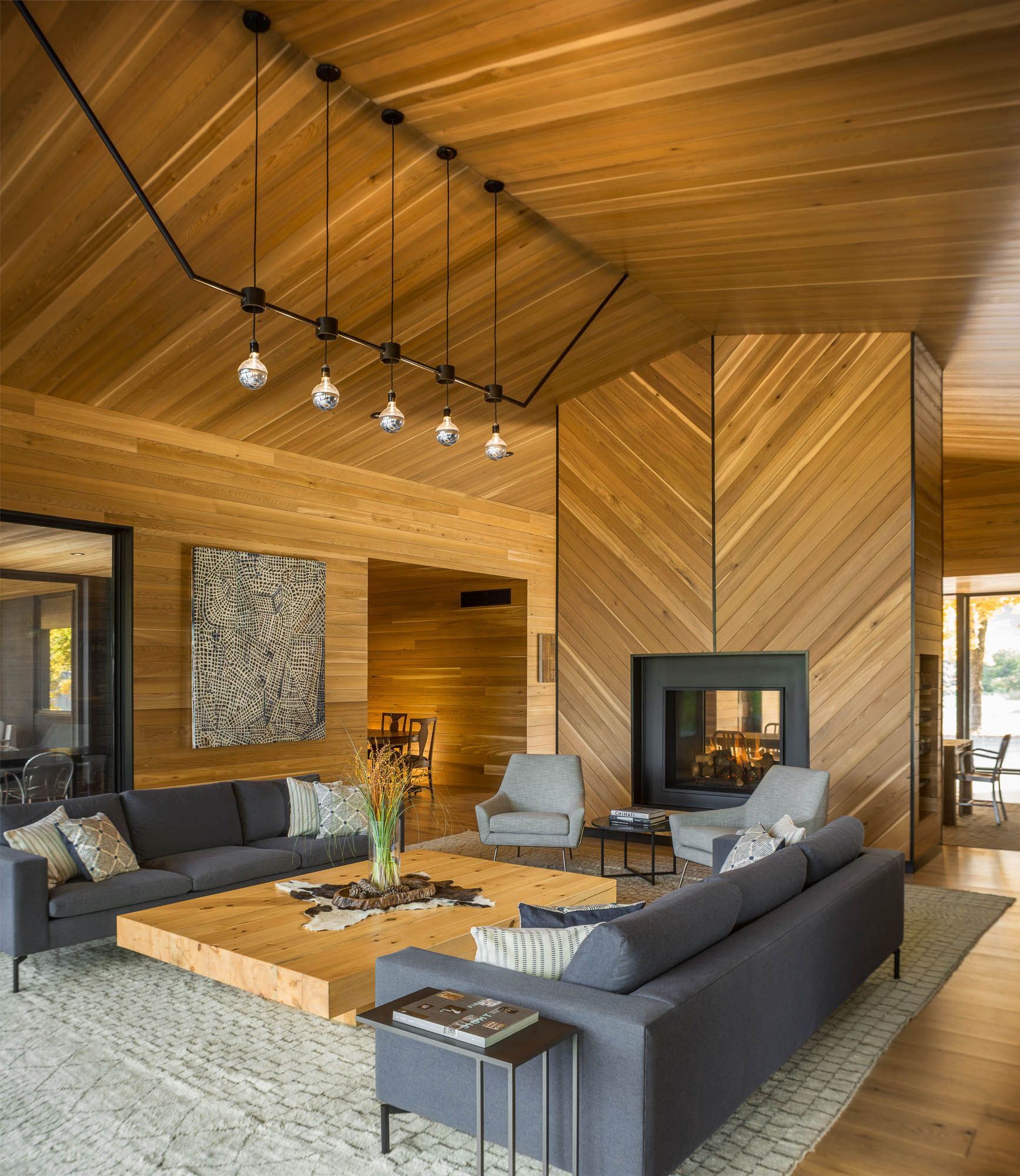 A living room with wood paneled walls and a fireplace