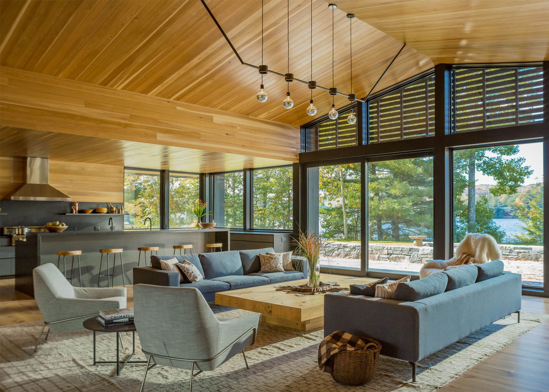 A living room with a lot of furniture and a lot of windows.