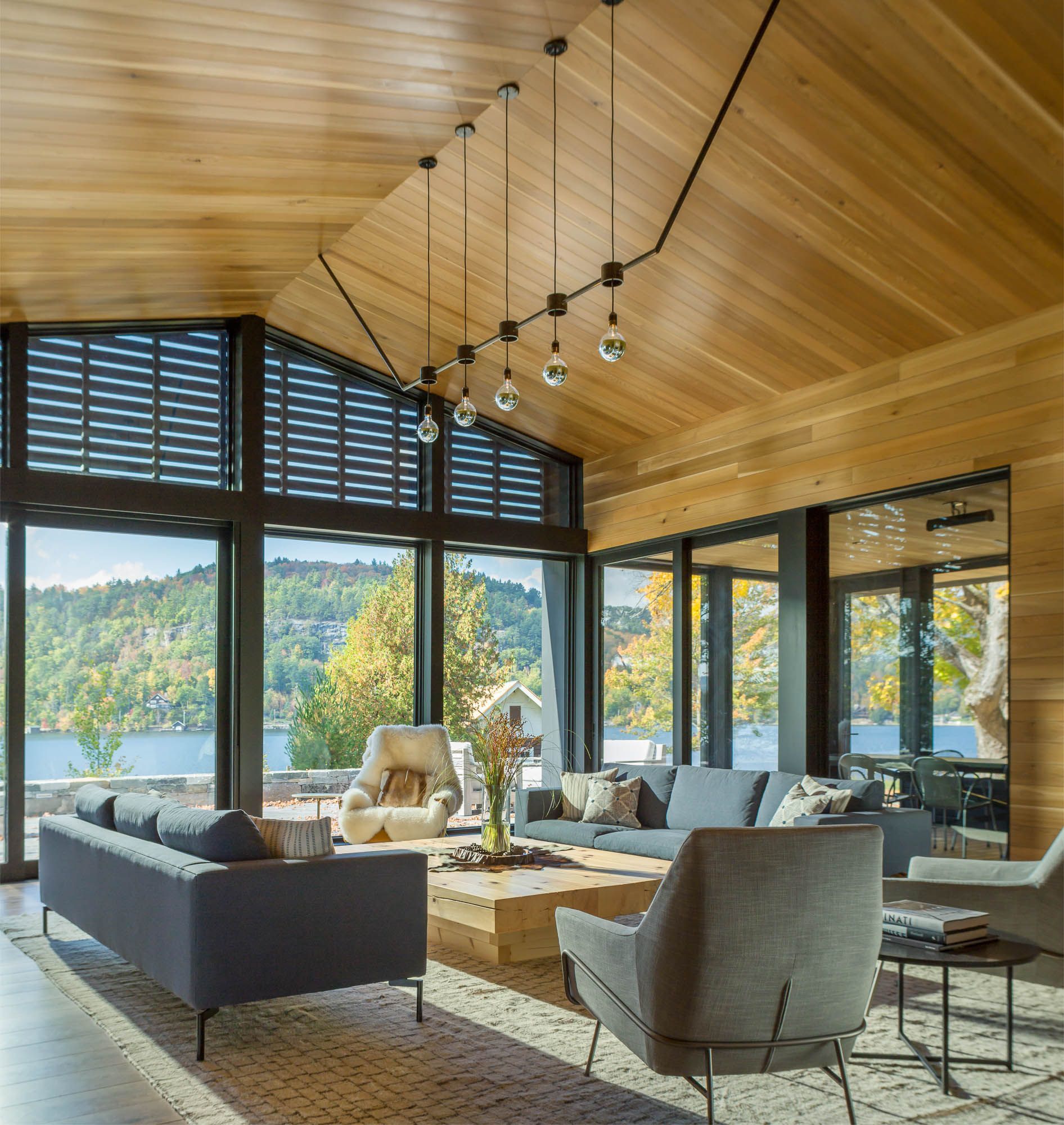 A living room with a lot of windows and a couch and chairs