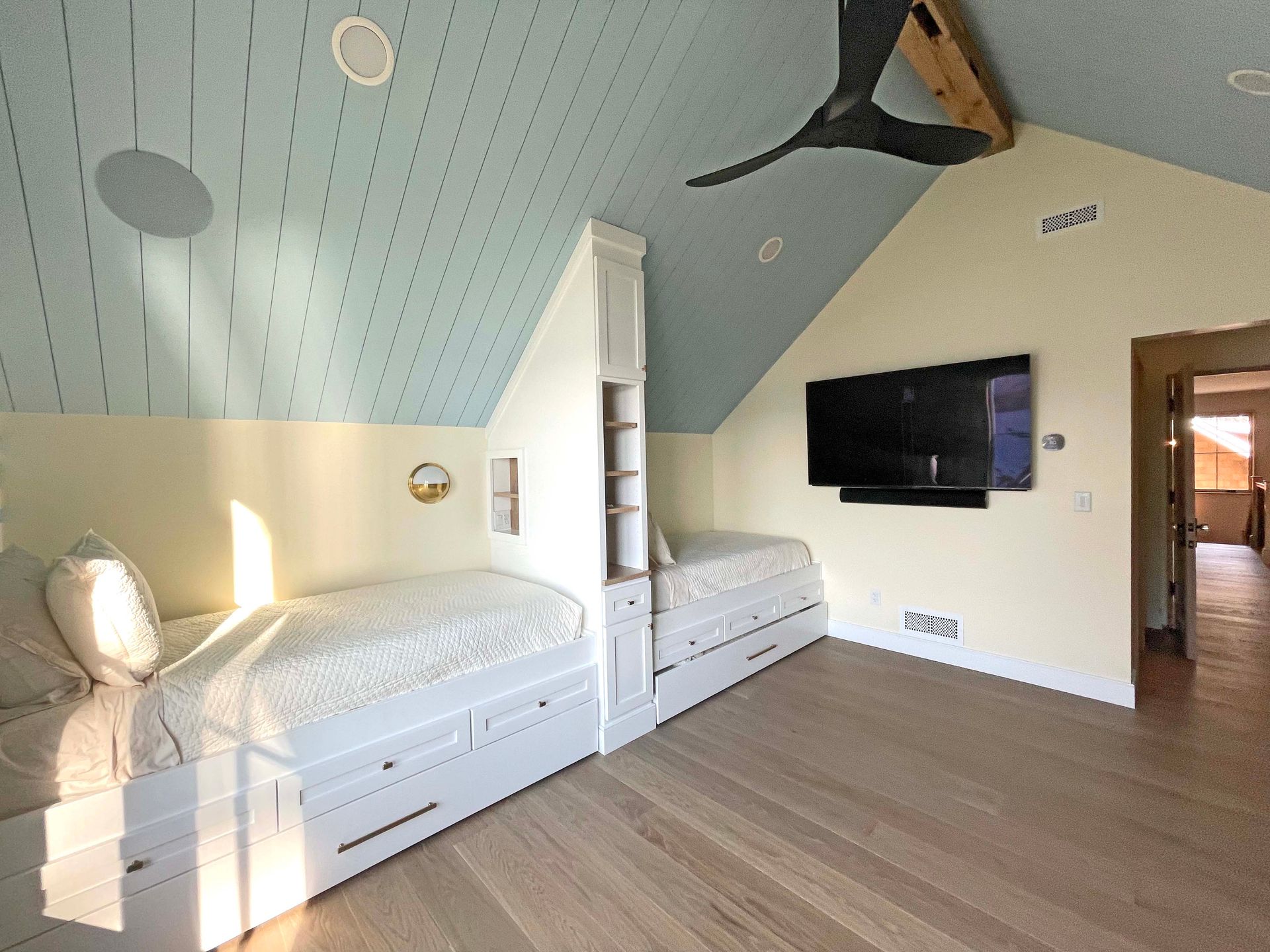 A bedroom with two beds and a flat screen tv