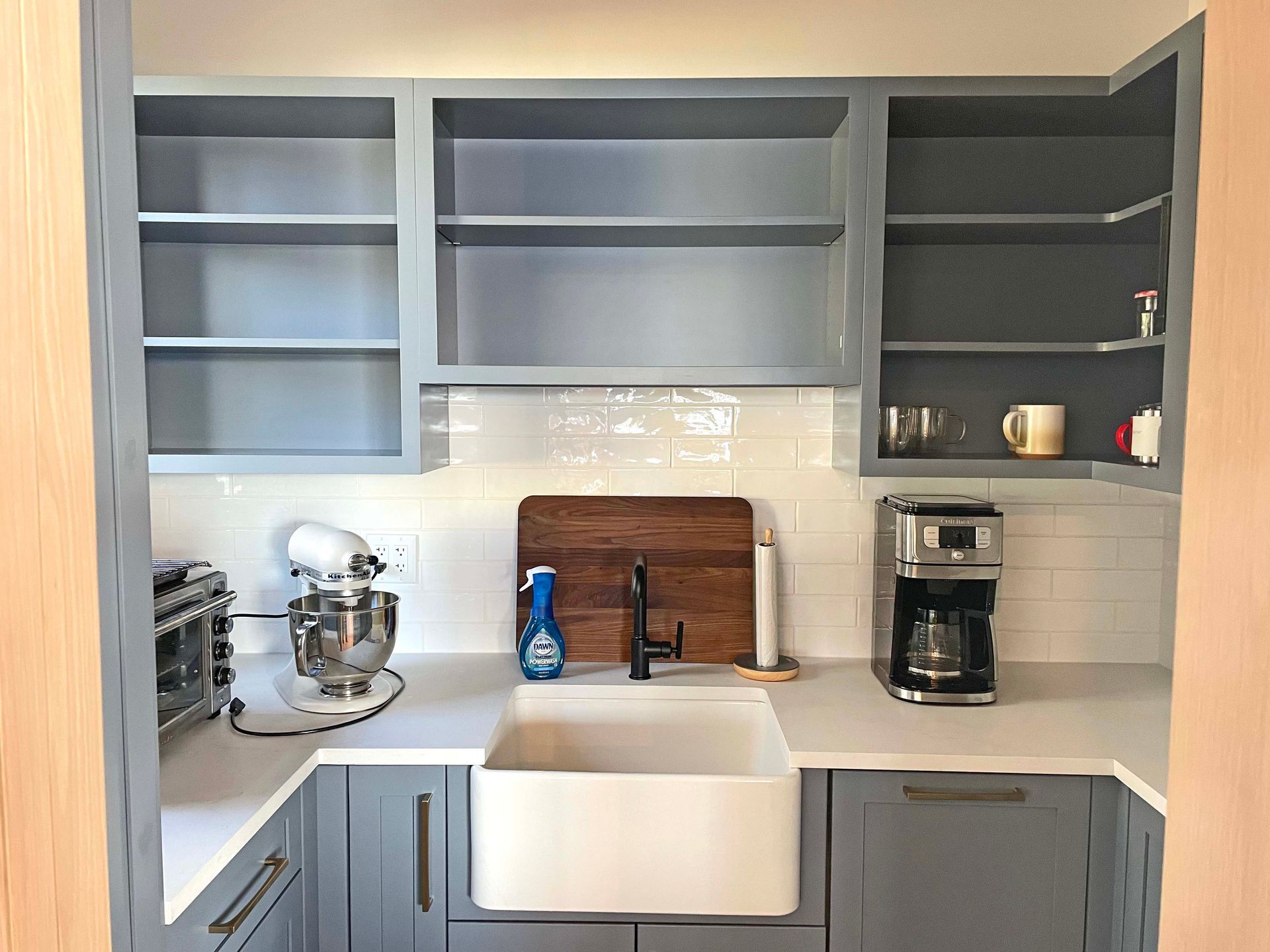 A kitchen with a sink , mixer , and coffee maker