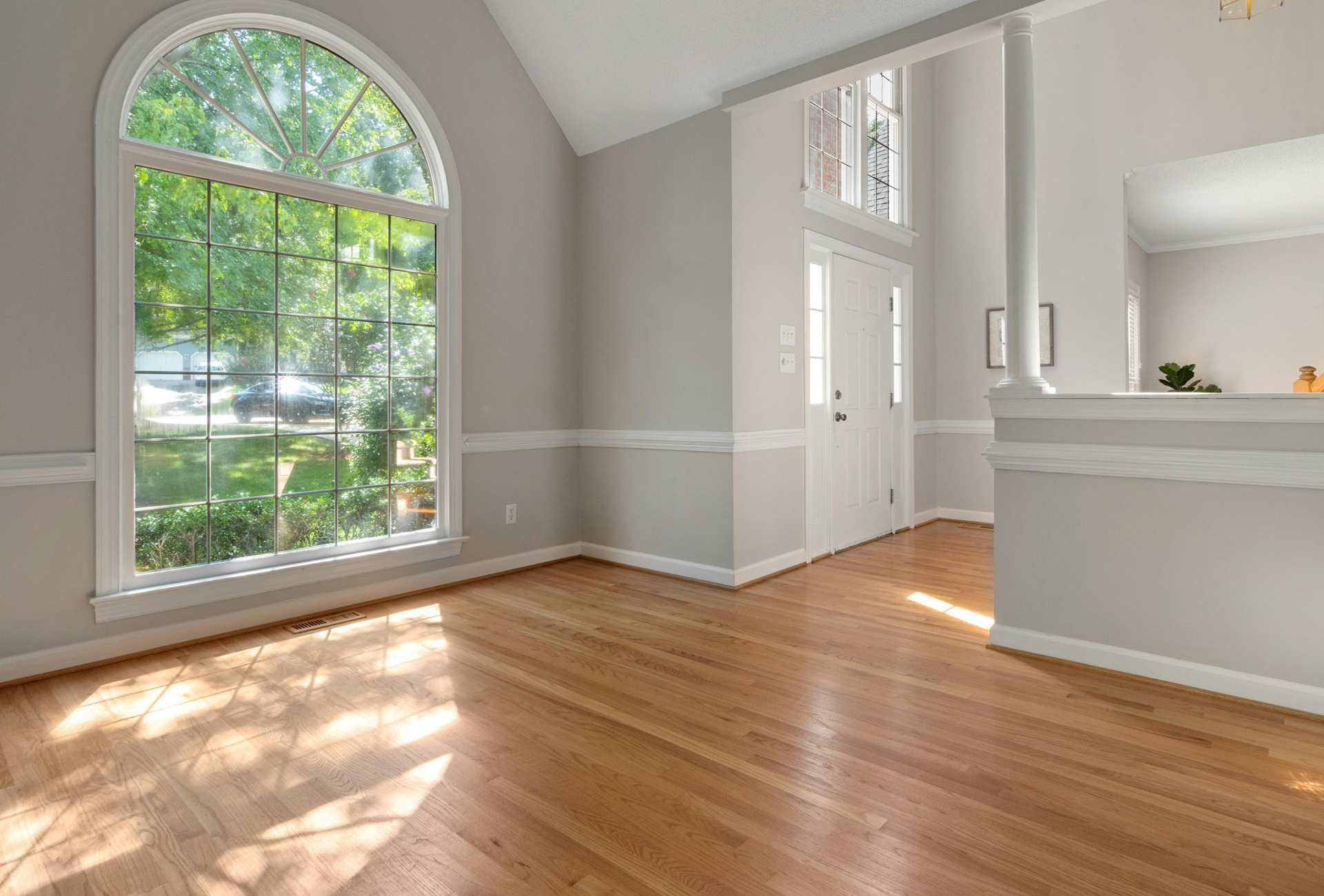 Yellow wet floor sign on polished floor, person cleaning with a floor buffer.