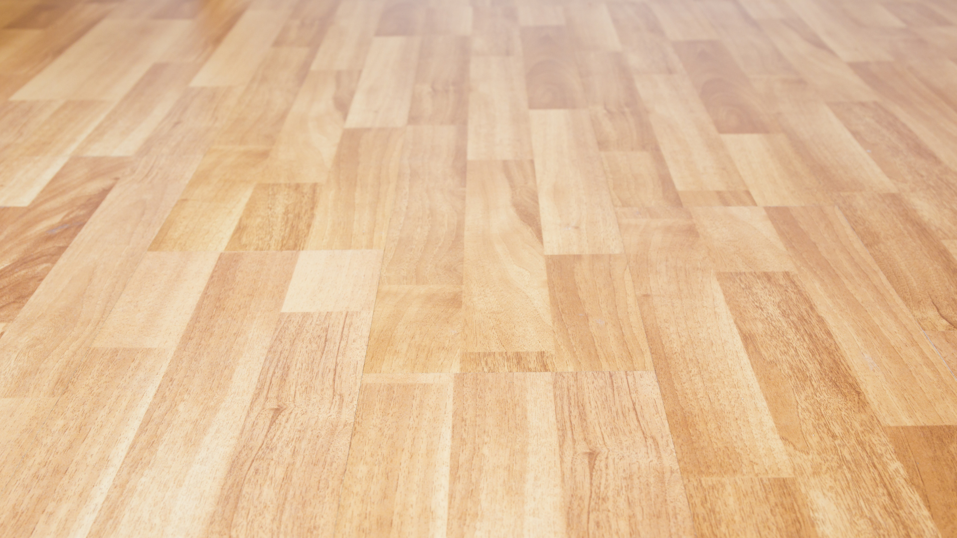 A close-up view of light-toned wooden floor planks arranged in a staggered, linear pattern.