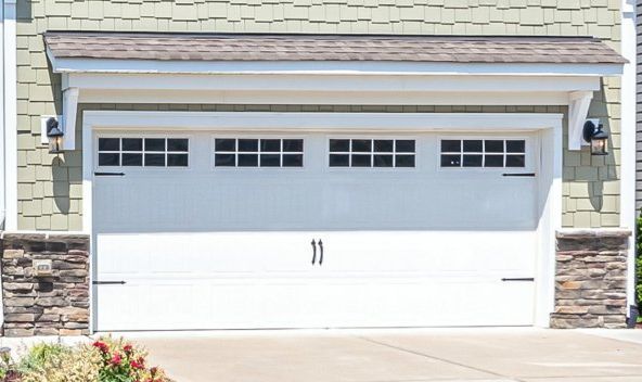 A large gray garage door is sitting in front of a house.