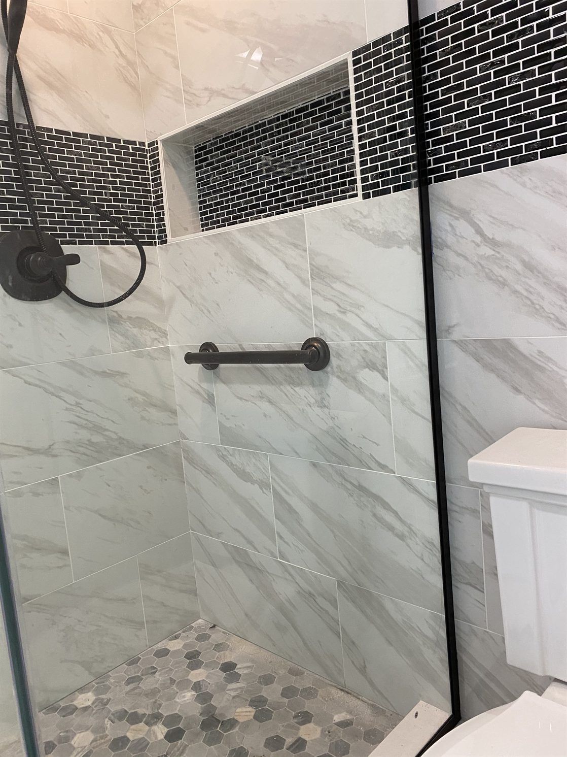 A bathroom with a walk in shower and a toilet.