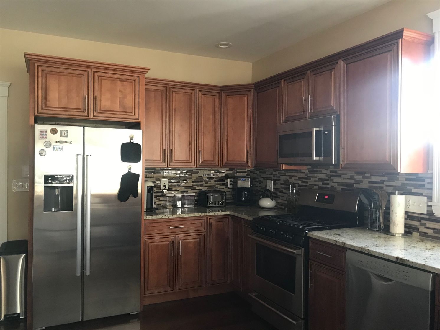 A kitchen with stainless steel appliances and wooden cabinets