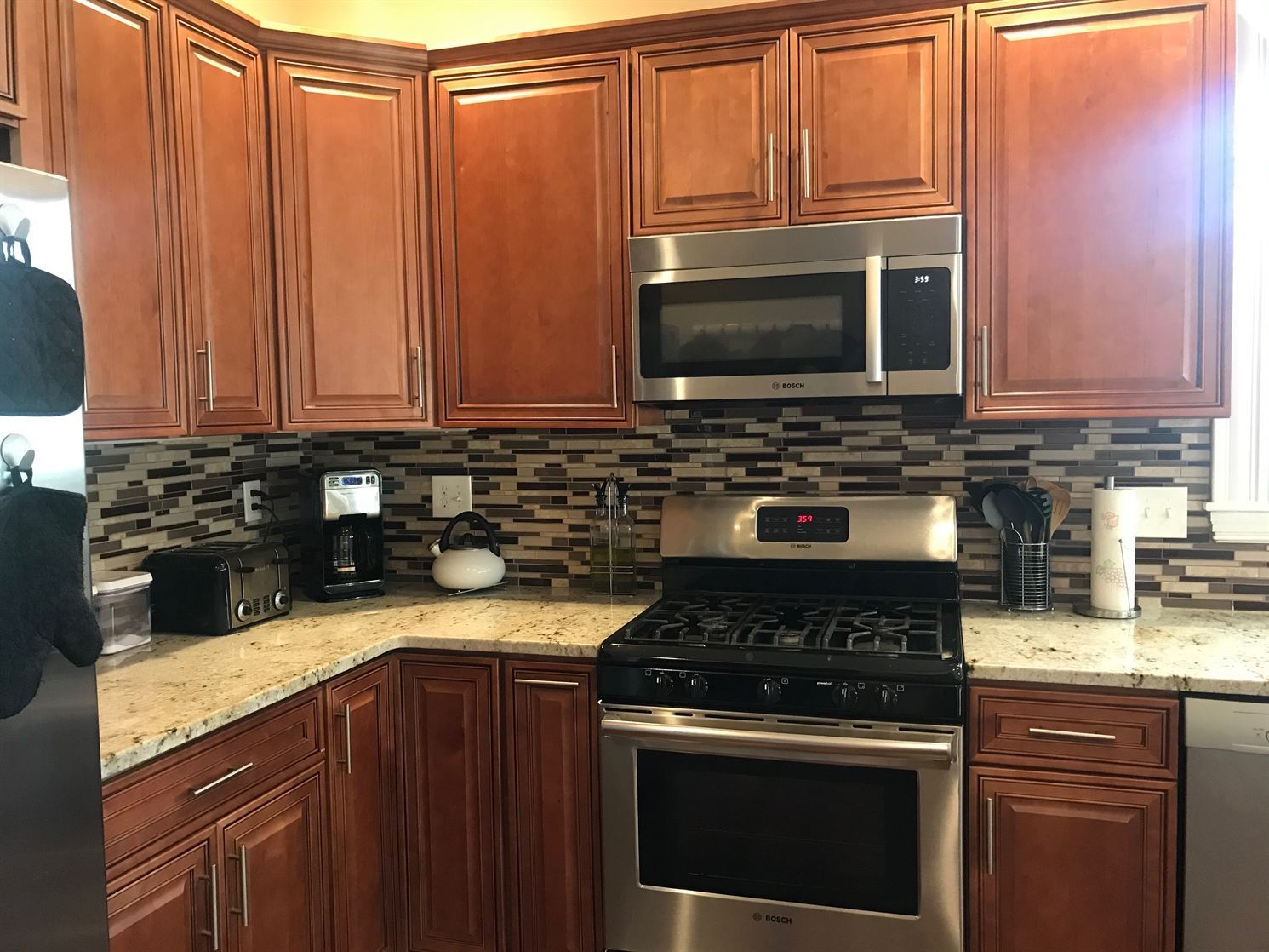 A kitchen with stainless steel appliances and wooden cabinets.