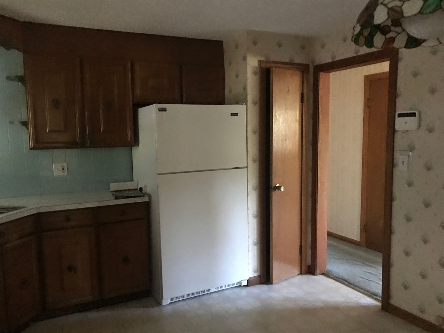 A kitchen with a white refrigerator and wooden cabinets