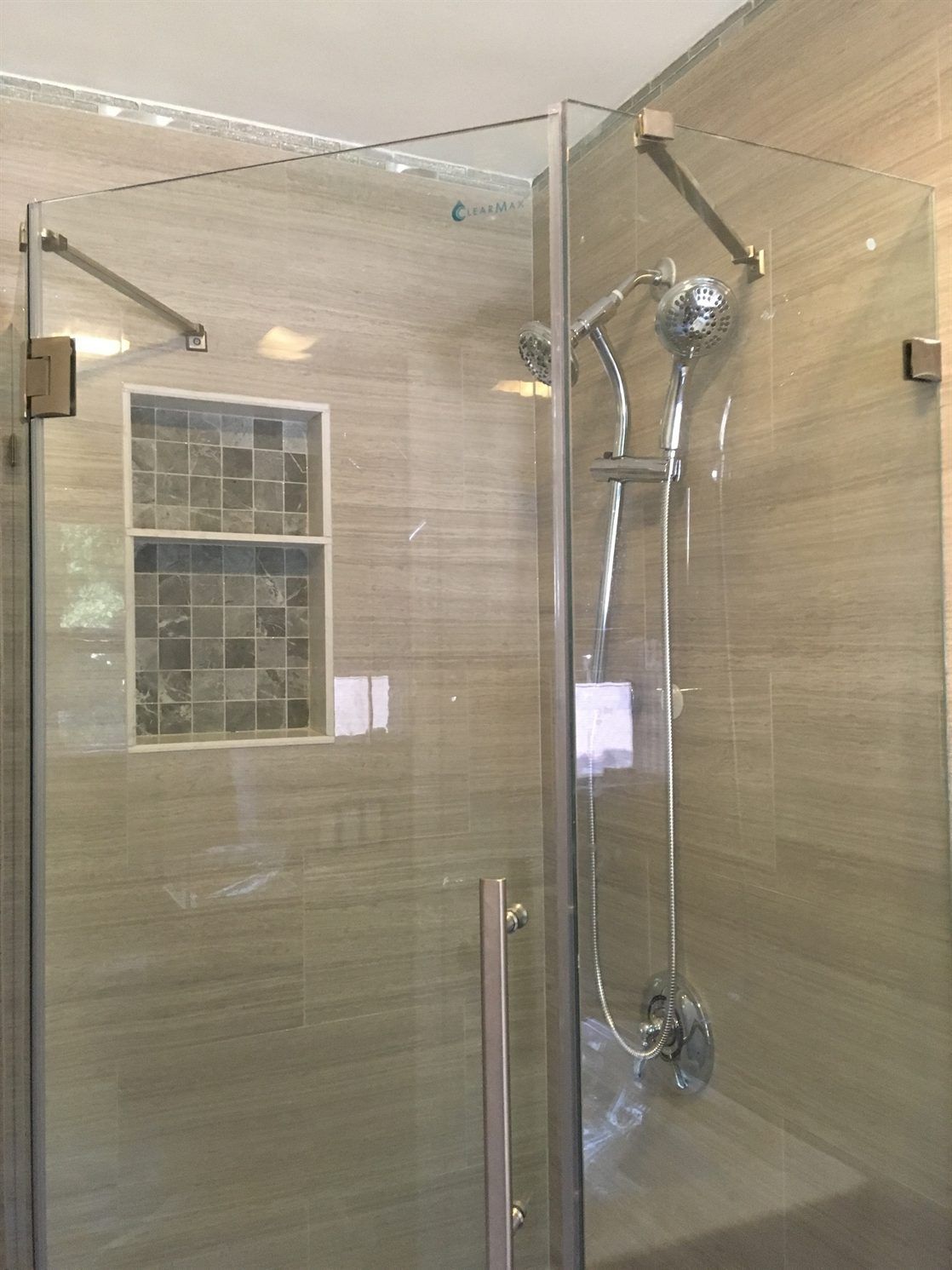 A shower stall with a glass door and a shower head.