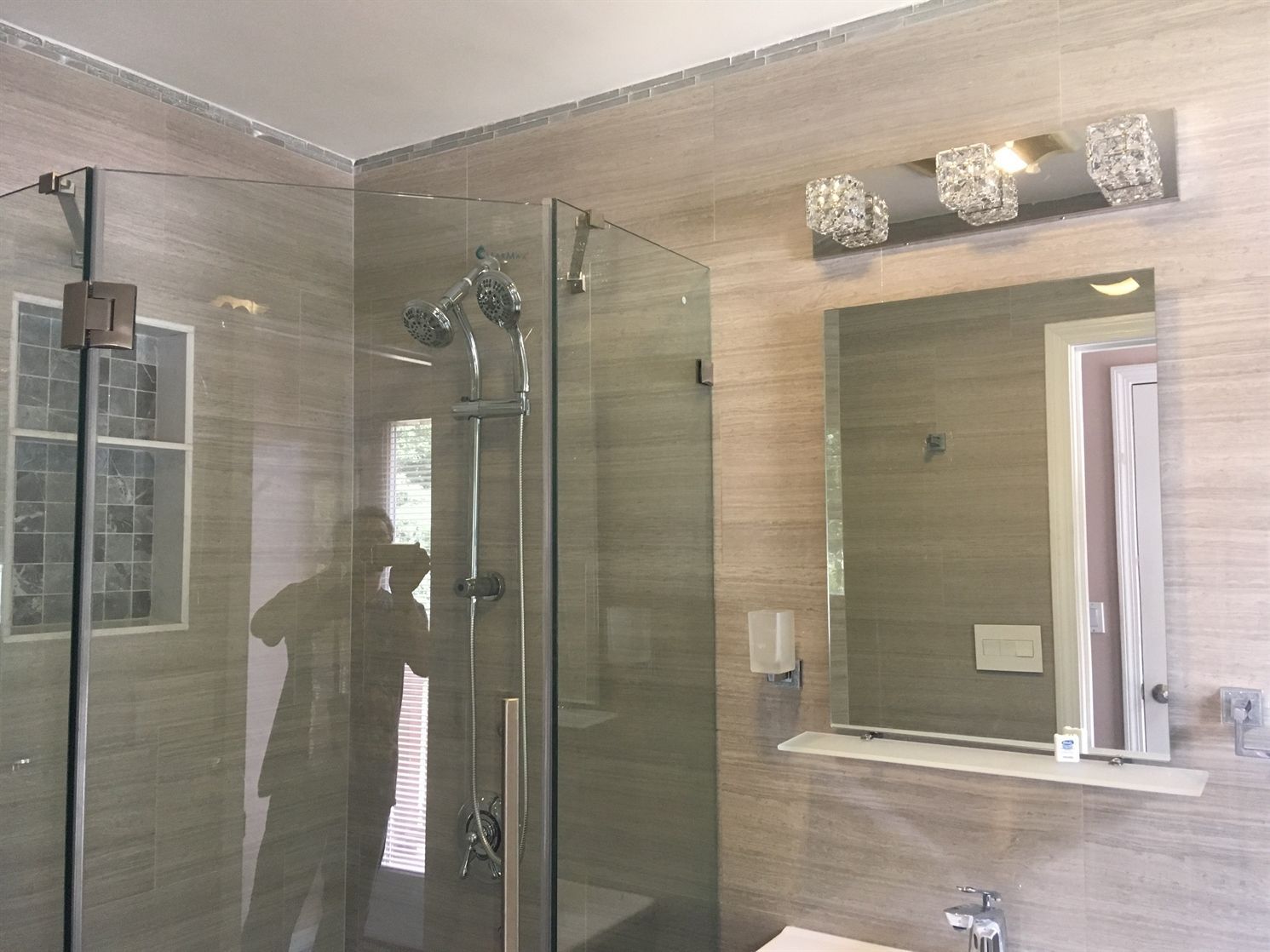 A bathroom with a walk in shower and a mirror.