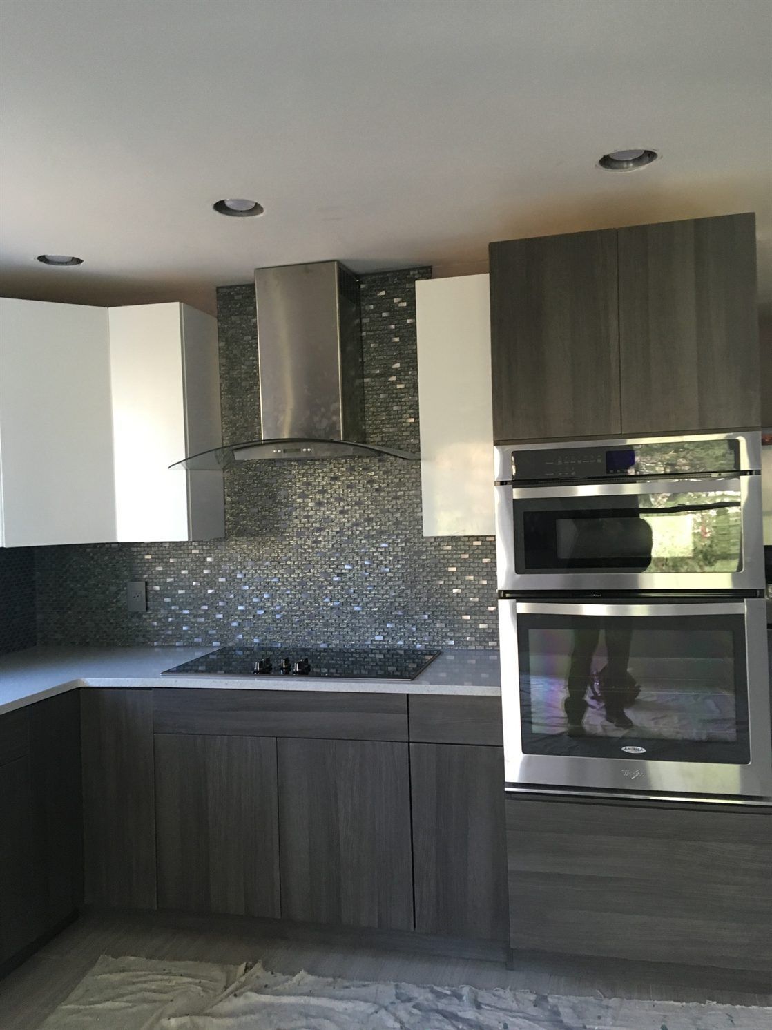 A kitchen with stainless steel appliances and gray cabinets