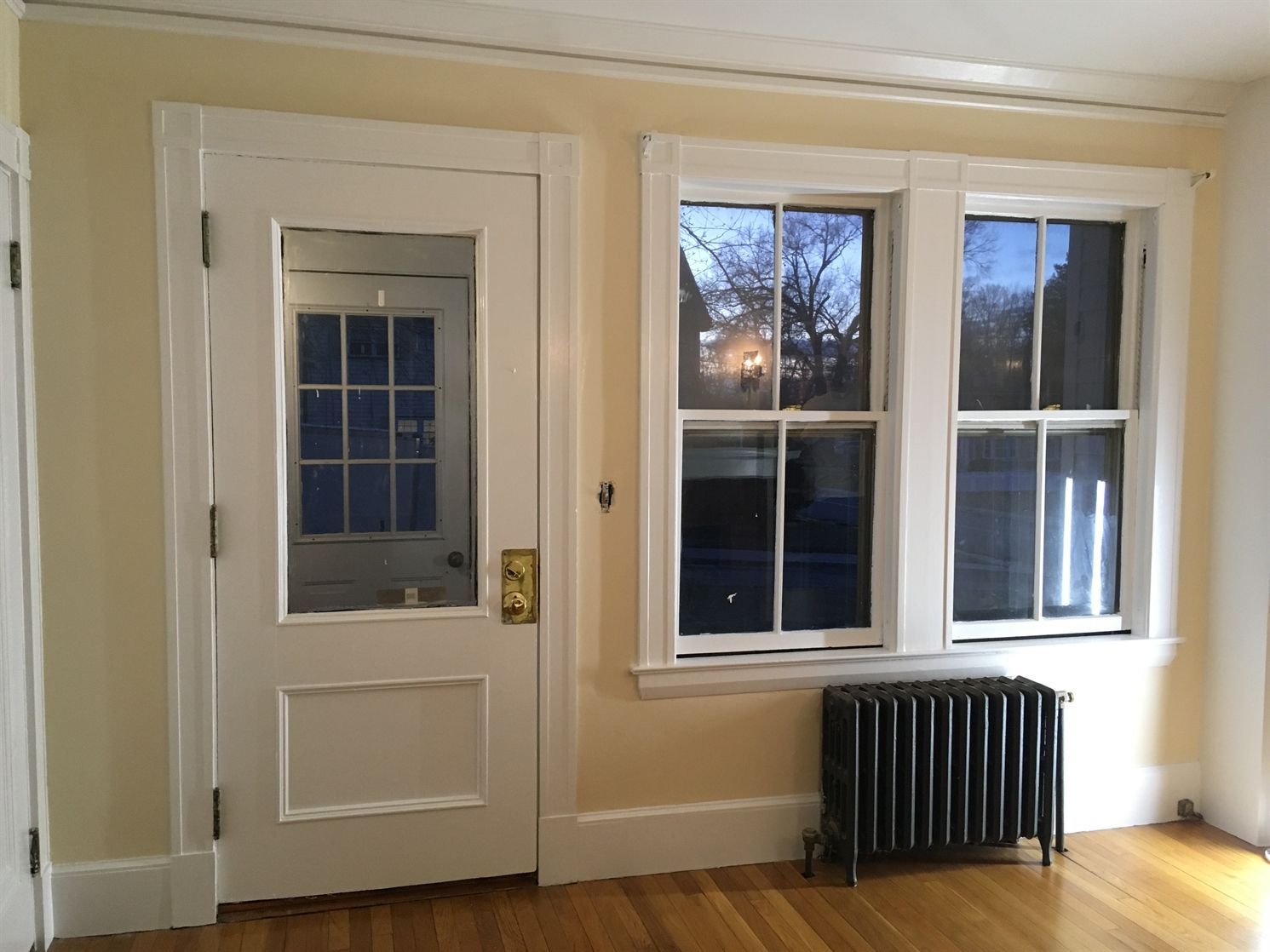 An empty room with two windows and a radiator