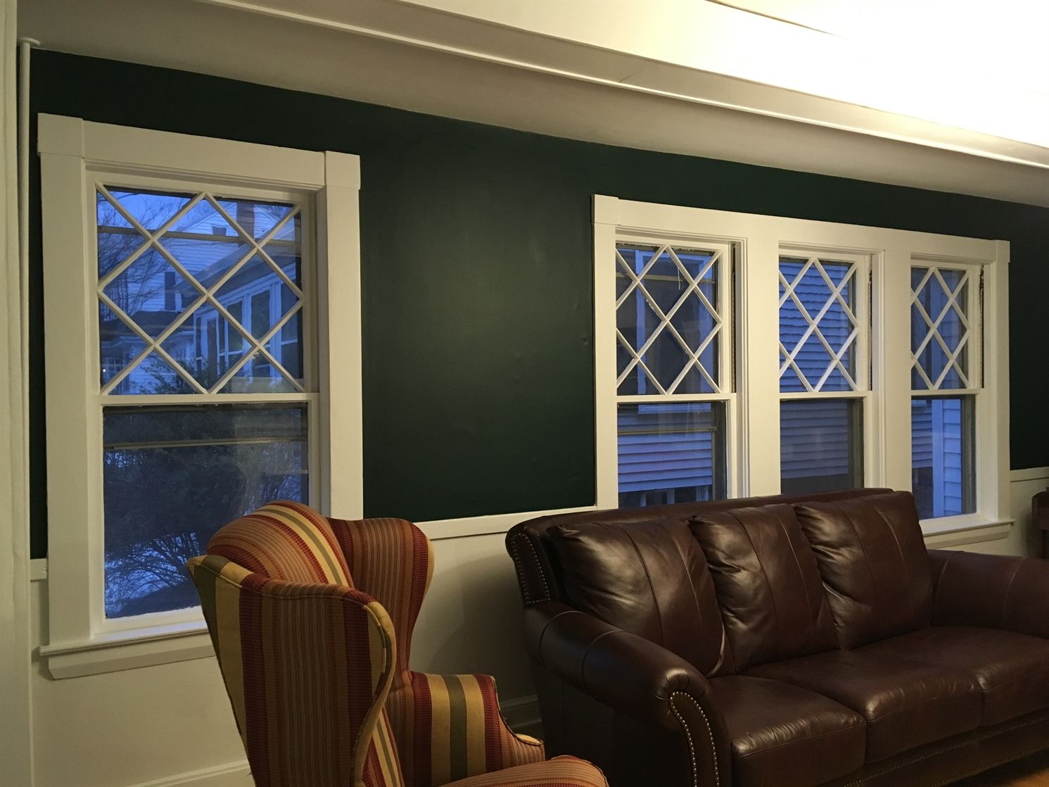 A living room with a brown couch and two chairs