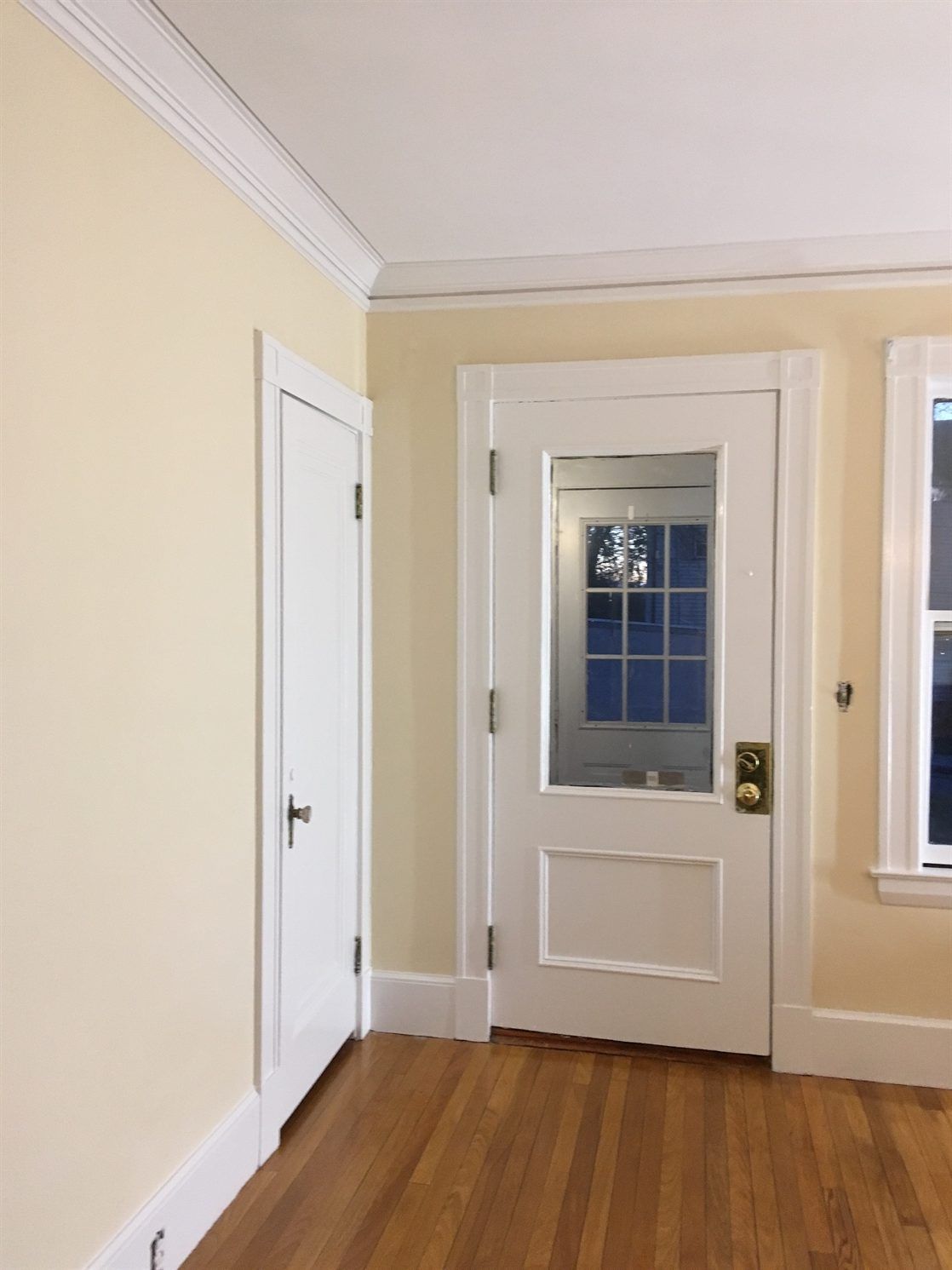 An empty room with a door and two windows