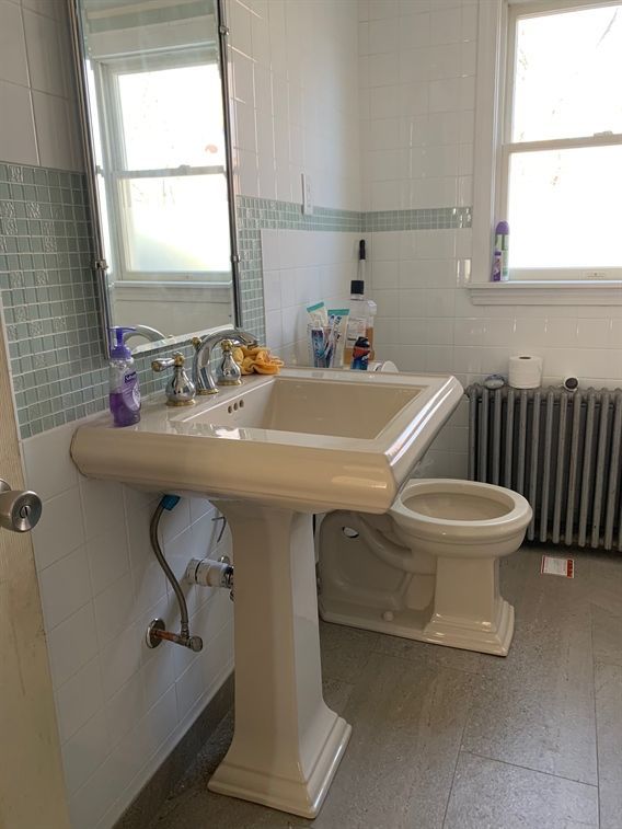 A bathroom with a sink , toilet and mirror.