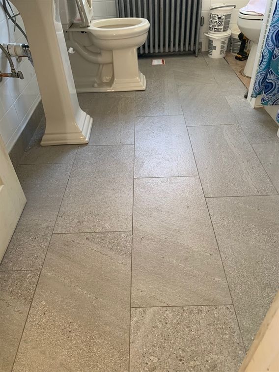 A bathroom with a toilet , sink , and radiator.