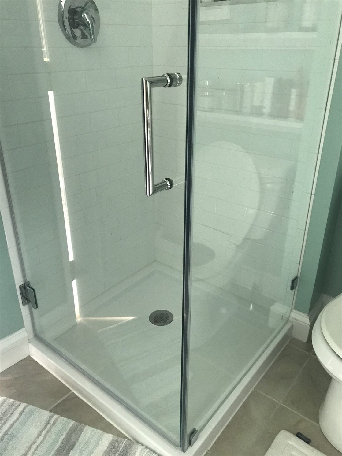 A bathroom with a toilet and a shower stall with a glass door.
