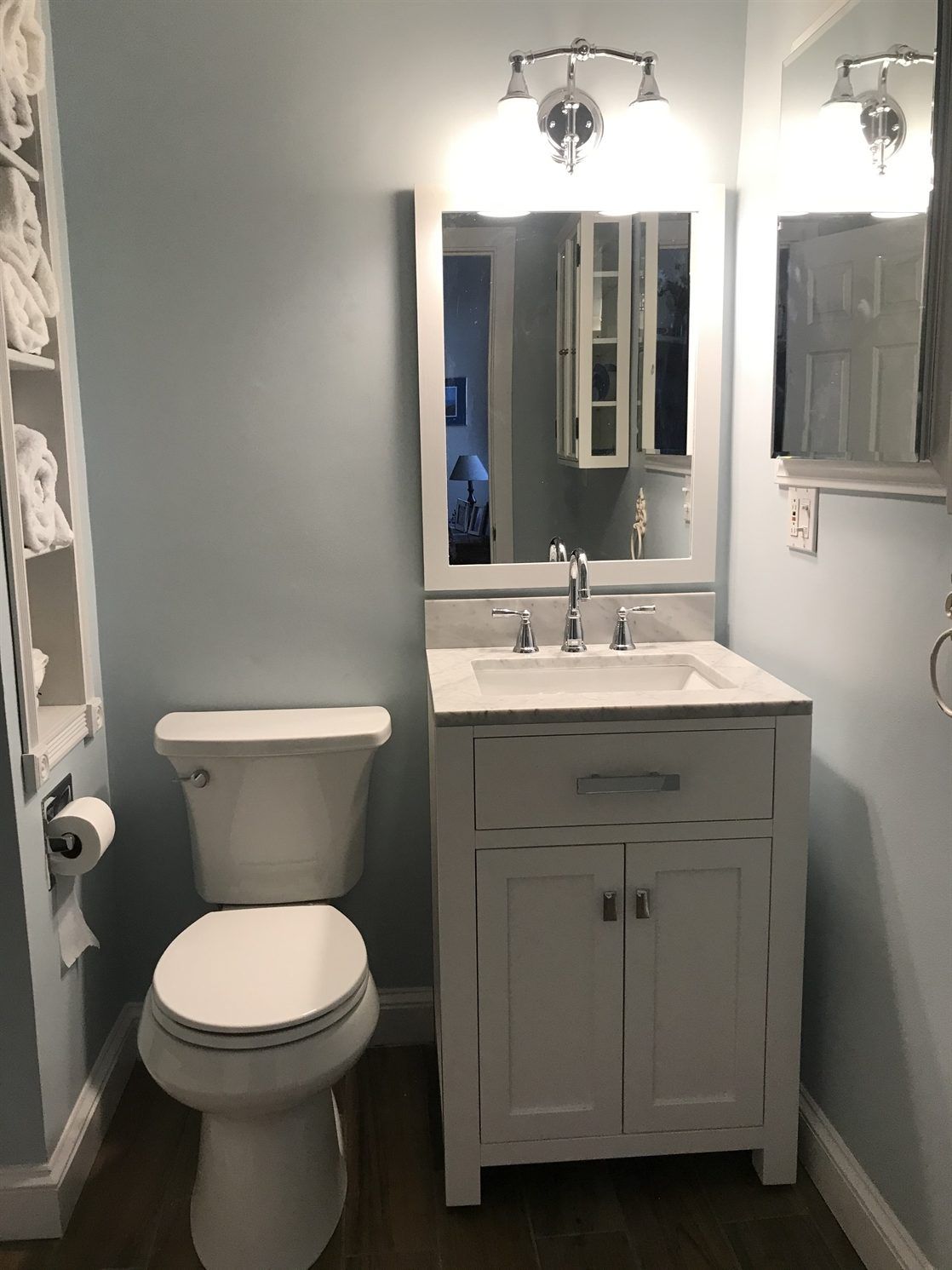 A bathroom with a toilet , sink and mirror