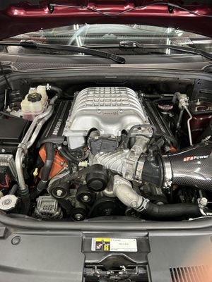 A man is working on the engine of a car.