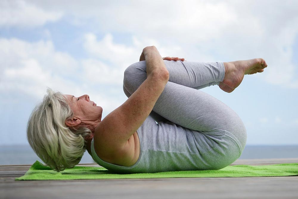 Woman Doing Yoga Against a Bright Blue Sky — Tustin, CA — Americana Senior Care