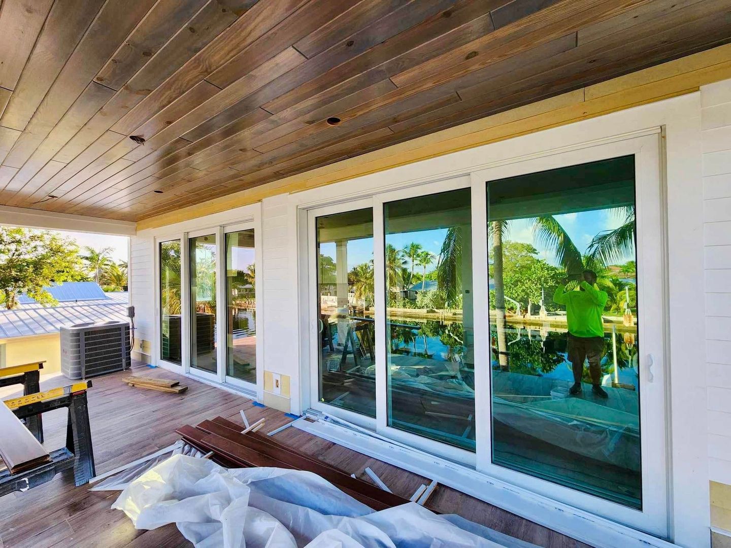 A man is installing sliding glass doors on a house.