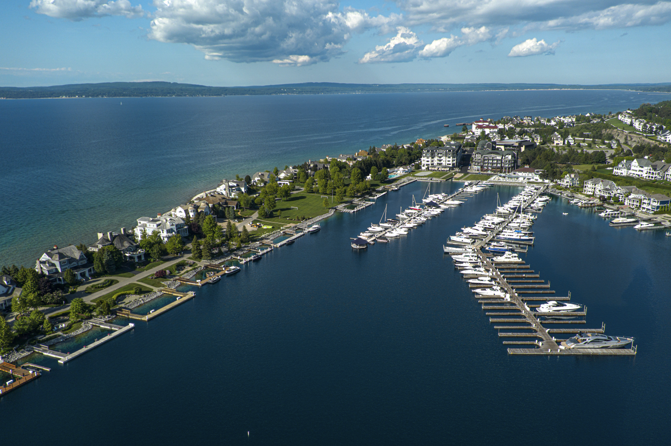 An aerial view of a marina filled with boats on a sunny day.